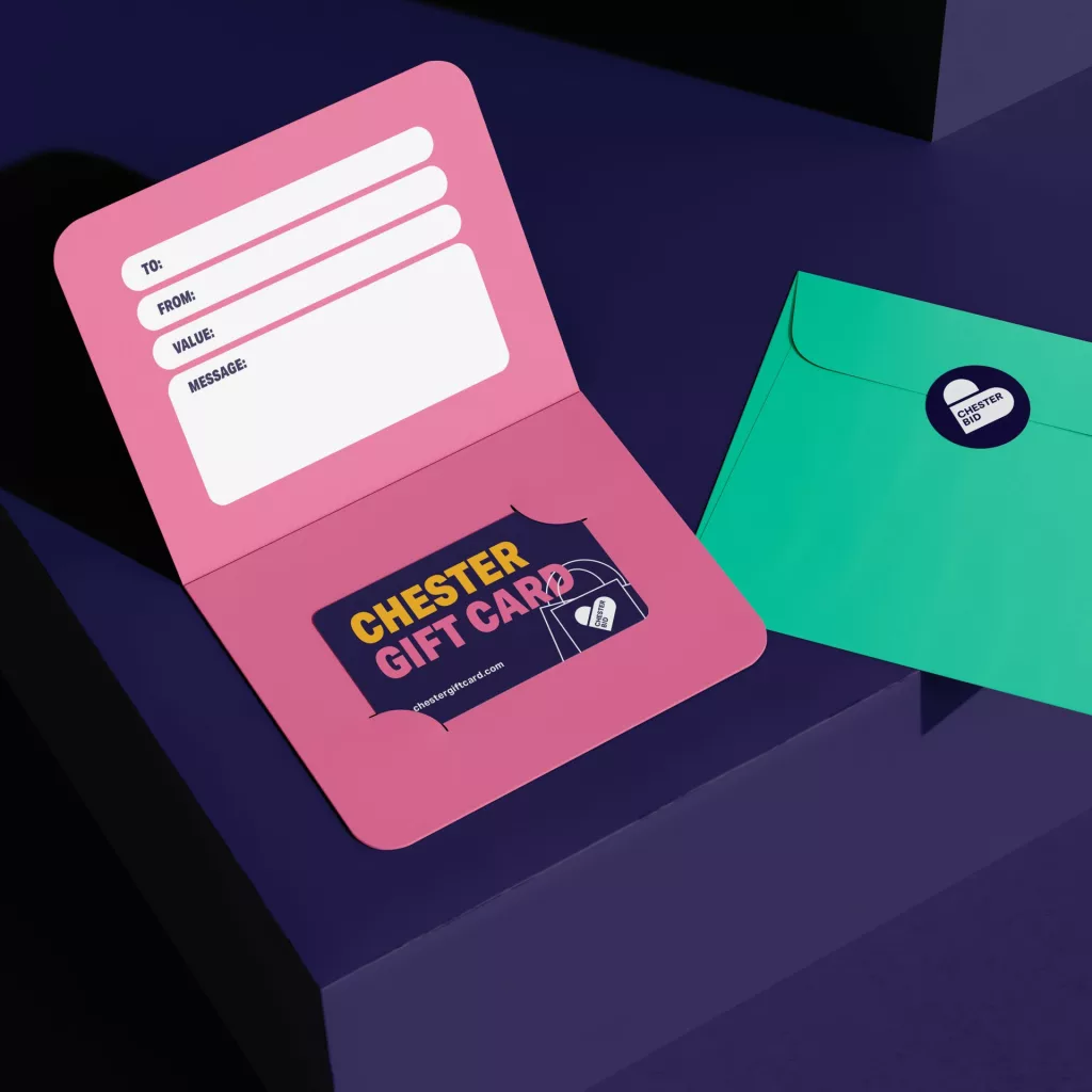 Pink gift-card holder with blank To/From/Value/Message fields and a navy Chester Gift Card, next to a teal envelope.
