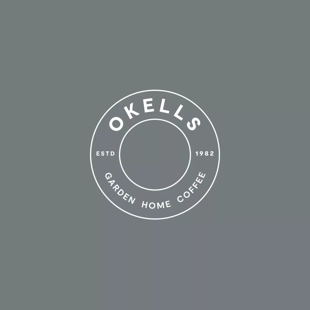 Circular grey logo with white double ring, OKELLS at top, ESTD 1982 at sides and GARDEN HOME COFFEE curved at bottom.
