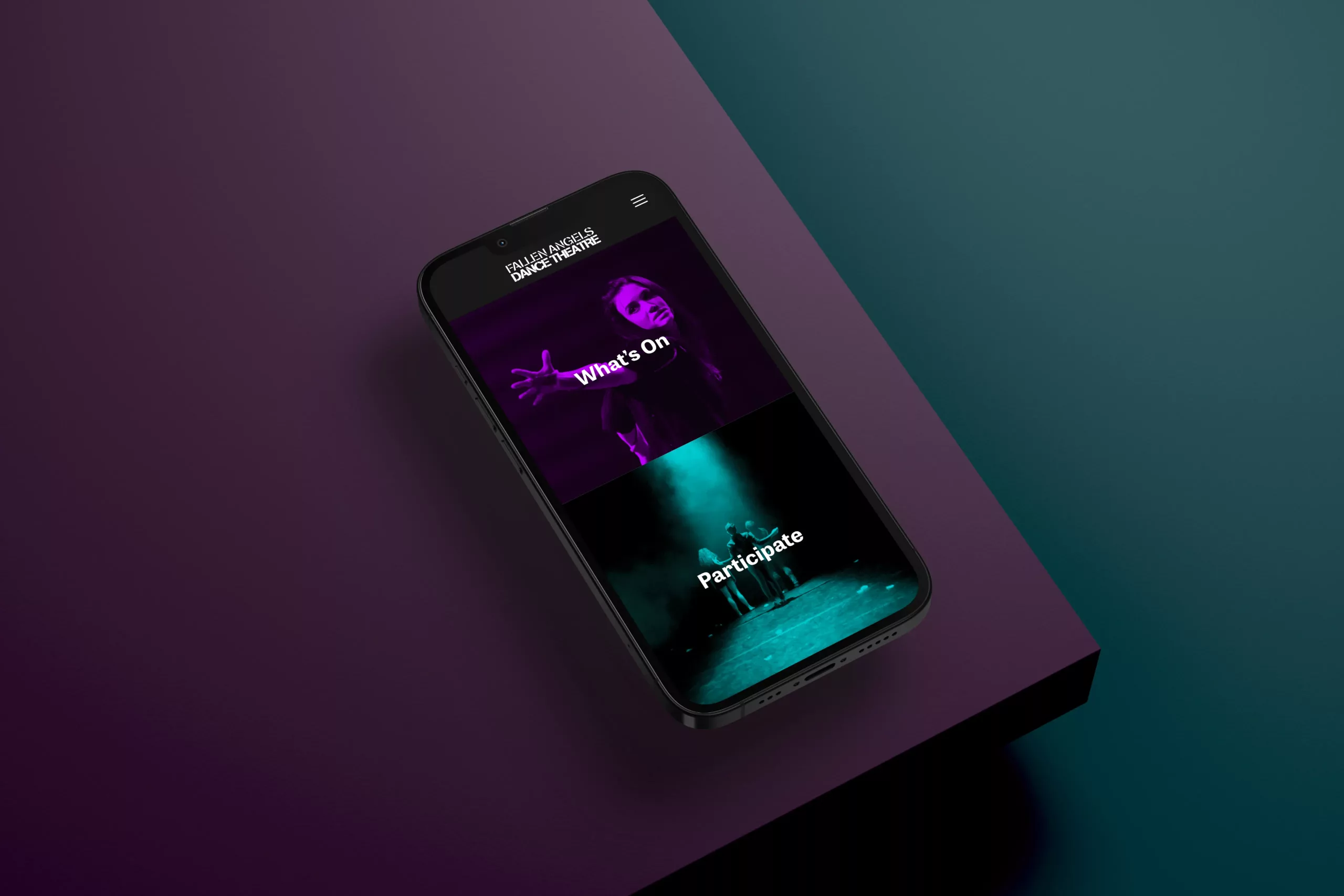 Phone on purple and teal surface showing a dance theatre site with What's On and Participate tiles.
