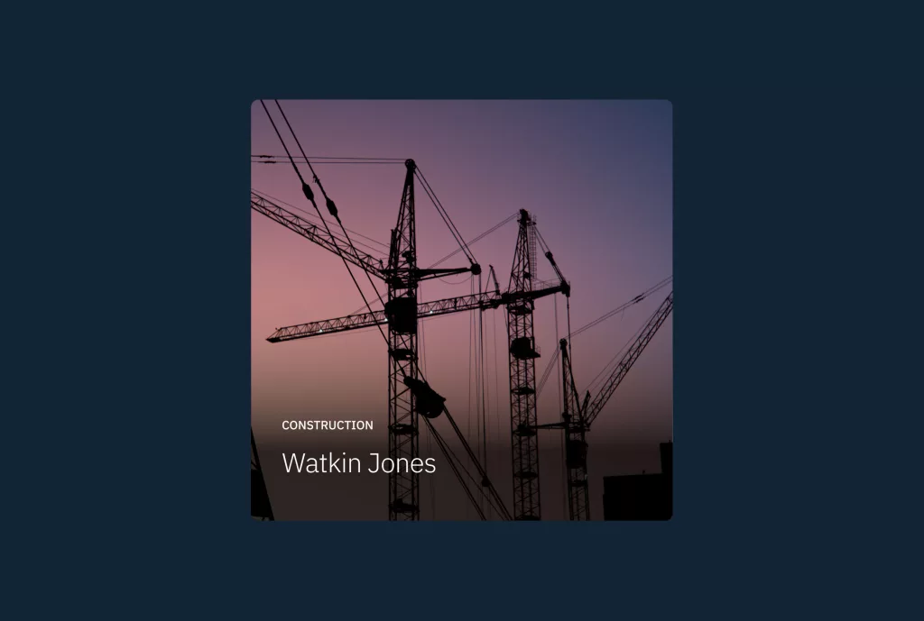 Silhouetted construction cranes against a purple-pink dusk sky with captions Construction and Watkin Jones.