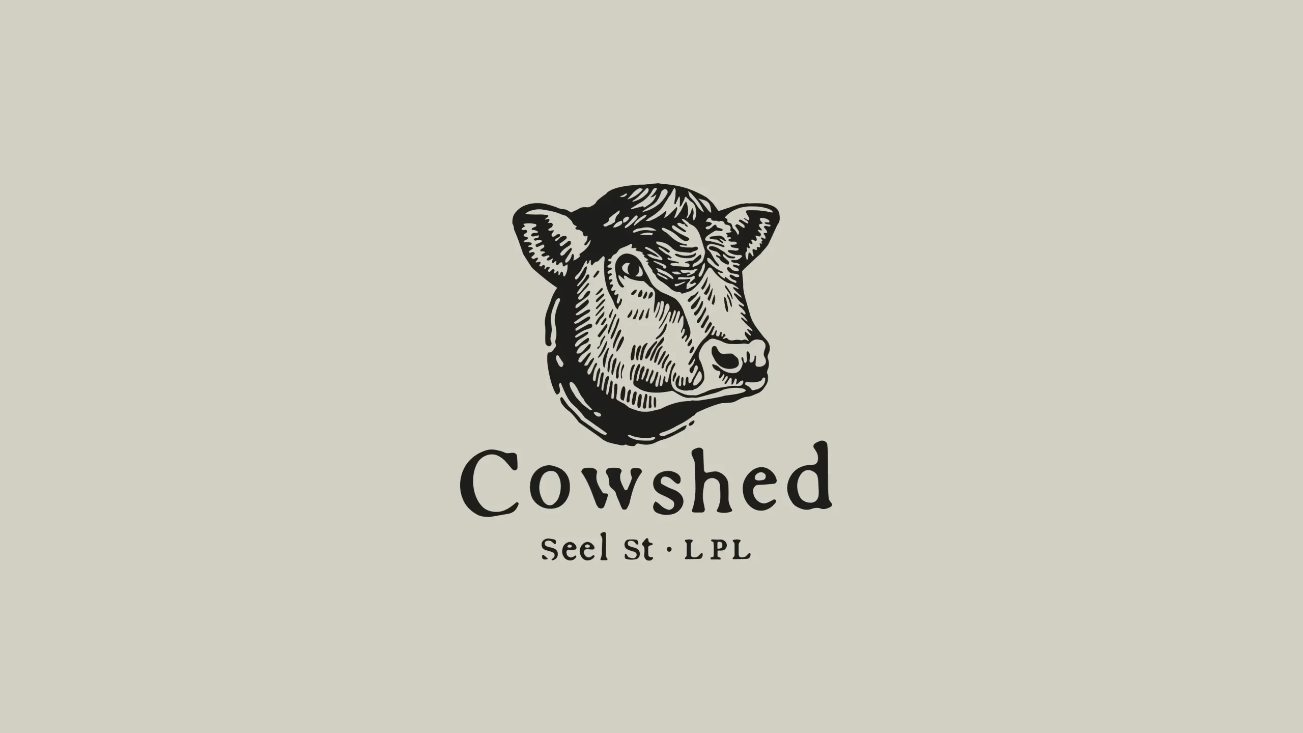 Black-and-white engraved cow head above the word Cowshed and tiny text Seel St · LPL on a pale beige background.